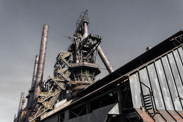 Monumental view, smokestacks and blast furnaces of steel mill industrial site, horizontal aspect