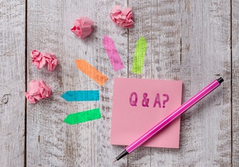 Conceptual hand writing showing Q And A Question. Concept meaning in which demonstrating asks questions and another one answers them Note paper and line arrow stickers on the top of wooden table desk
