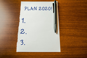 Handwriting text Plan 2020. Conceptual photo detailed proposal for doing or achieving something next year Upper view blank stationary paper lying wooden table pen. Writing essay