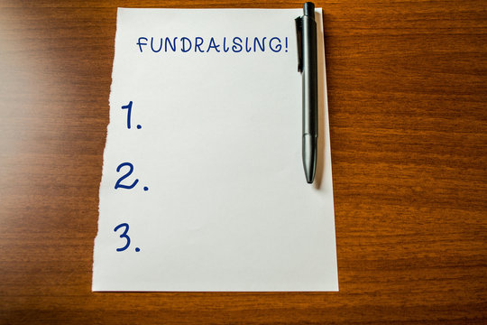 Handwriting text Fundraising. Conceptual photo seeking to generate financial support for charity or cause Upper view blank stationary paper lying wooden table pen. Writing essay