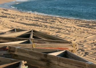 Wooden frames for beach huts lying on sand in early summer awaiting tourists