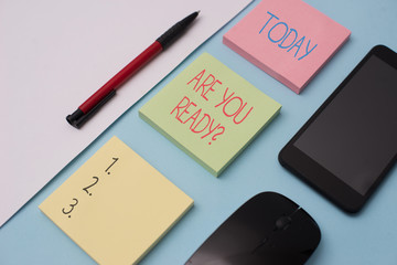Writing note showing Are You Ready Question. Business concept for used telling someone start something when feel prepared Note papers and stationary plus gadgets placed sideways above backdrop