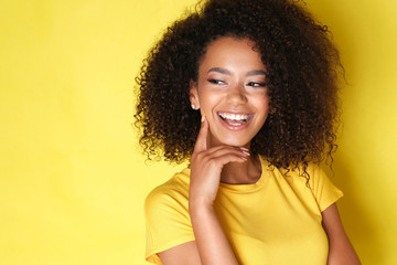 Close up of a happy afro model laughing and looking at the side.
