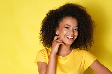 Close up of a happy afro model laughing and looking at the side.