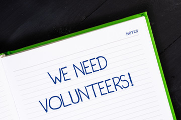 Text sign showing We Need Volunteers. Business photo showcasing someone who does work without being paid for it Close up view corner blank page notebook. Writing ideas projects goals