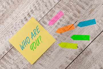 Word writing text Who Are You question. Business photo showcasing asking about demonstrating identity or demonstratingal information Plain note paper and line arrow stickers on the top of wooden table