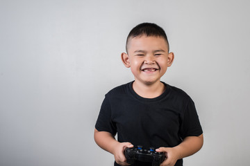 Happy boy play game computer with a controller in studio photo