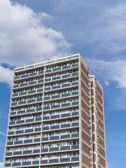 Tower social housing building against blue sky with clouds