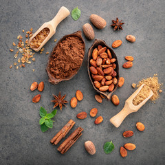 Cocoa powder and cacao beans on stone background.