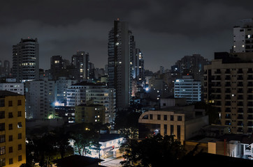 Fototapeta na wymiar Buildings of Sao Paulo city at a cloudy night. Urban photo of the city during night.
