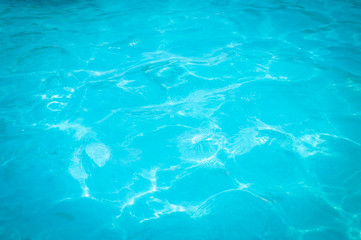 Swimming pool blue water reflecting the sun rippled details. 