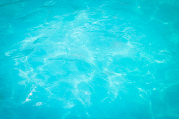 Swimming pool blue water reflecting the sun rippled details. 