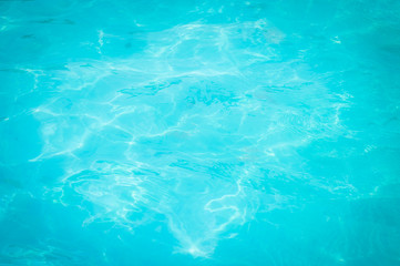 Swimming pool blue water reflecting the sun rippled details. 