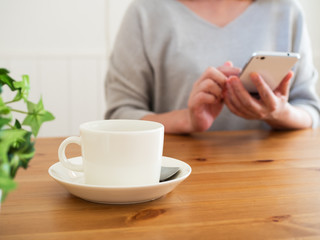 カフェでスマートフォンを見る女性