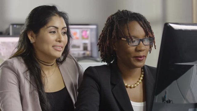 Two professional women working together at a computer