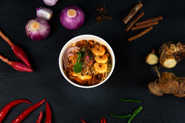  Malaysian Assam Laksa on a dark wooden table with ingredients spread on the table