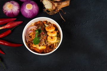  Malaysian Assam Laksa on a dark wooden table with ingredients spread on the table