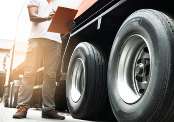 truck driver is inspecting safety of truck tire.