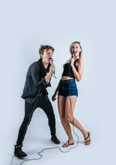 Fototapeta premium Happy portrait of Couple holding microphone and sing a song