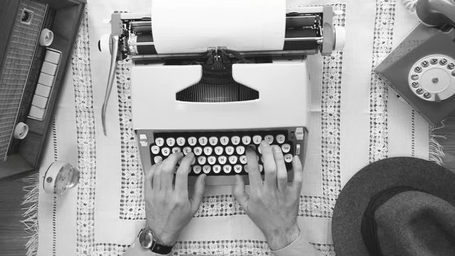Typing on a typewriter top view. 50's 60's 70's vintage scene. Historical reenactment concept.