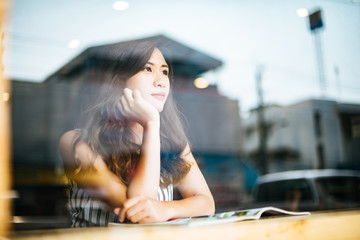 Beautiful woman reading magazine in cafe