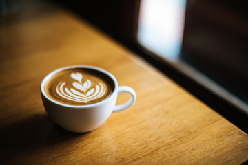 Latte art in coffee cup on the cafe table