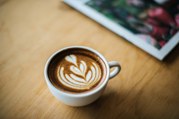 Latte art in coffee cup on the cafe table