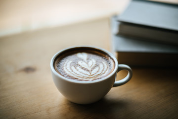 Latte art in coffee cup on the cafe table