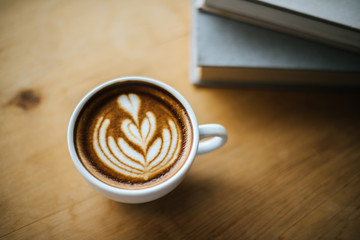 Latte art in coffee cup on the cafe table