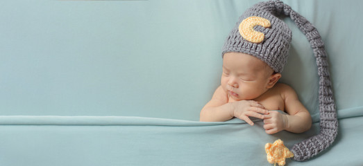 Adorable newborn baby sleeping in cozy room. Cute happy infant baby portrait with sleepy face in...