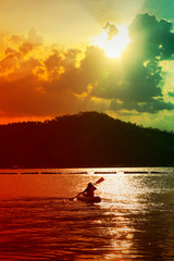 kayaking on the lake and sunset on behind the mountain background