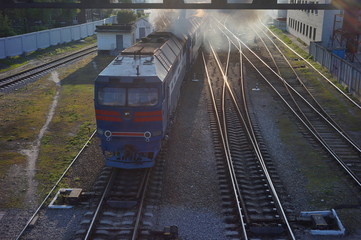 Steam train traveling along the railway line with steam bellowing out the sides and the top