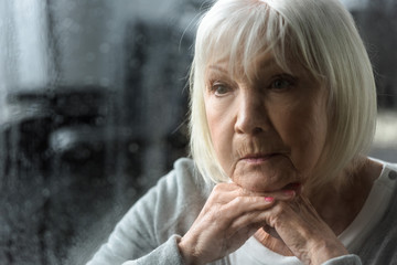 sad senior woman with grey hair looking away