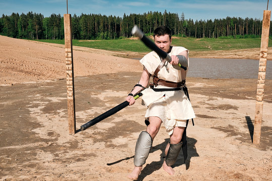 Concept photo of a Roman warrior of the Colosseum in action with aggressive emotions in full military uniforms on a desert landscape on a sunny day with a dry sun.