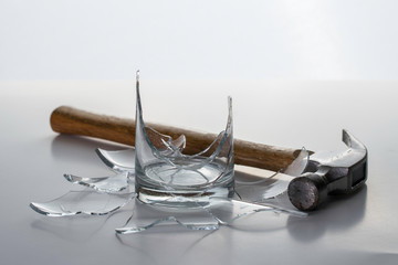 Broken Glass with hammer and shattered glass pieces. Alcoholism Addiction Concept