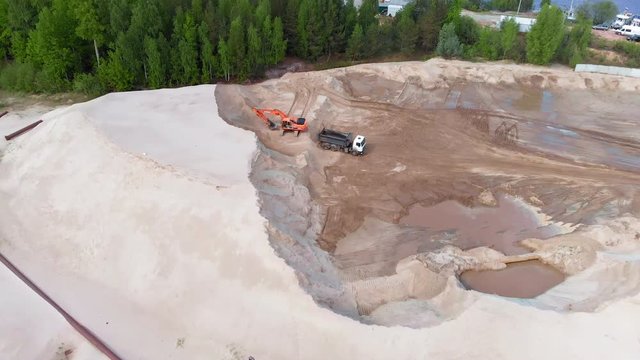 Sand quarry. Work excavator and dump truck. Aerial shooting