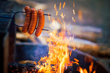 Preparing sausage on campfire, camping dinner