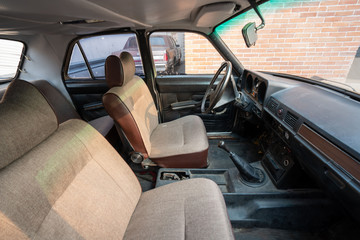 An old car parked next to a brick wall
