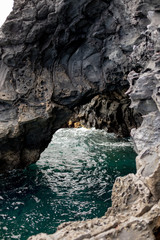 Naklejka na ściany i meble Rocky arch in the ocean near the beach