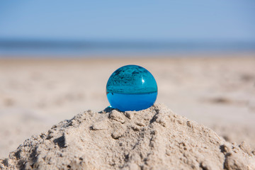 Fototapeta na wymiar Glass sphere at the beach. Sunny summer day.