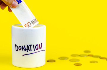 money box with coins and banknotes on a yellow background. moneybox donate concept