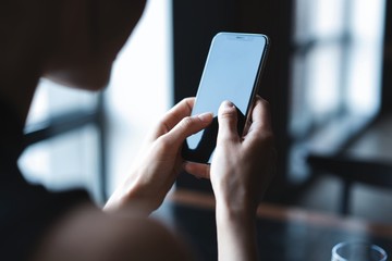 business woman using smartphone during lunch in cafe.