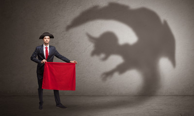 Businessman standing with red cloth in his hand and imp shadow on the background
