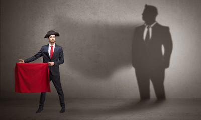 Businessman standing with red cloth on his hand and his shadow on the background
