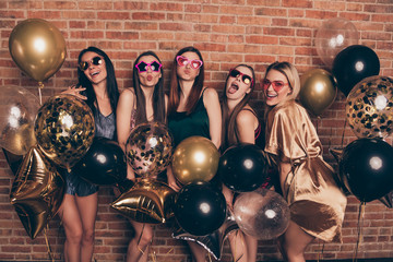 Portrait of nice cool company attractive alluring winsome lovely cheerful cheery crazy playful excited ecstatic ladies having fun birthday event tradition  isolated over industrial brick wall