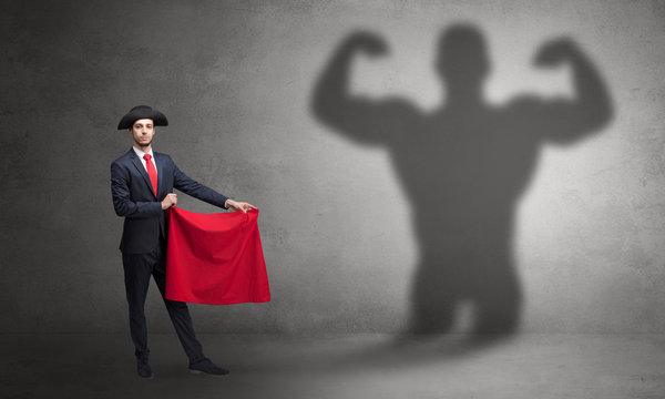 Businessman standing with red cloth on his hand and strong hero shadow on the background
