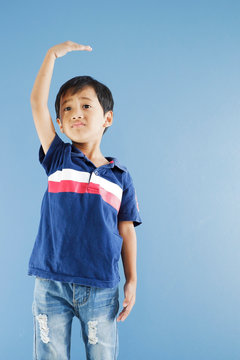 boy standing and lift up the hand for scaling his height