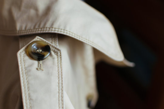 woman trench closeup details: button and collar. Gabardine fabric and button