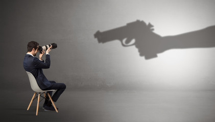 Small businessman staying and offering stuffs for an armed shadow hand
