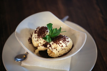 Ice cream balls in a white bowl in a cafe, dark